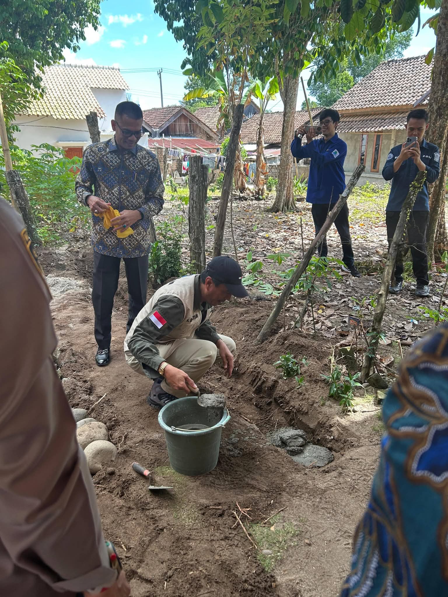 Tampak berdiri Sekda Kadin Perkim sedang meletakkan batu pertama program bedah rumah